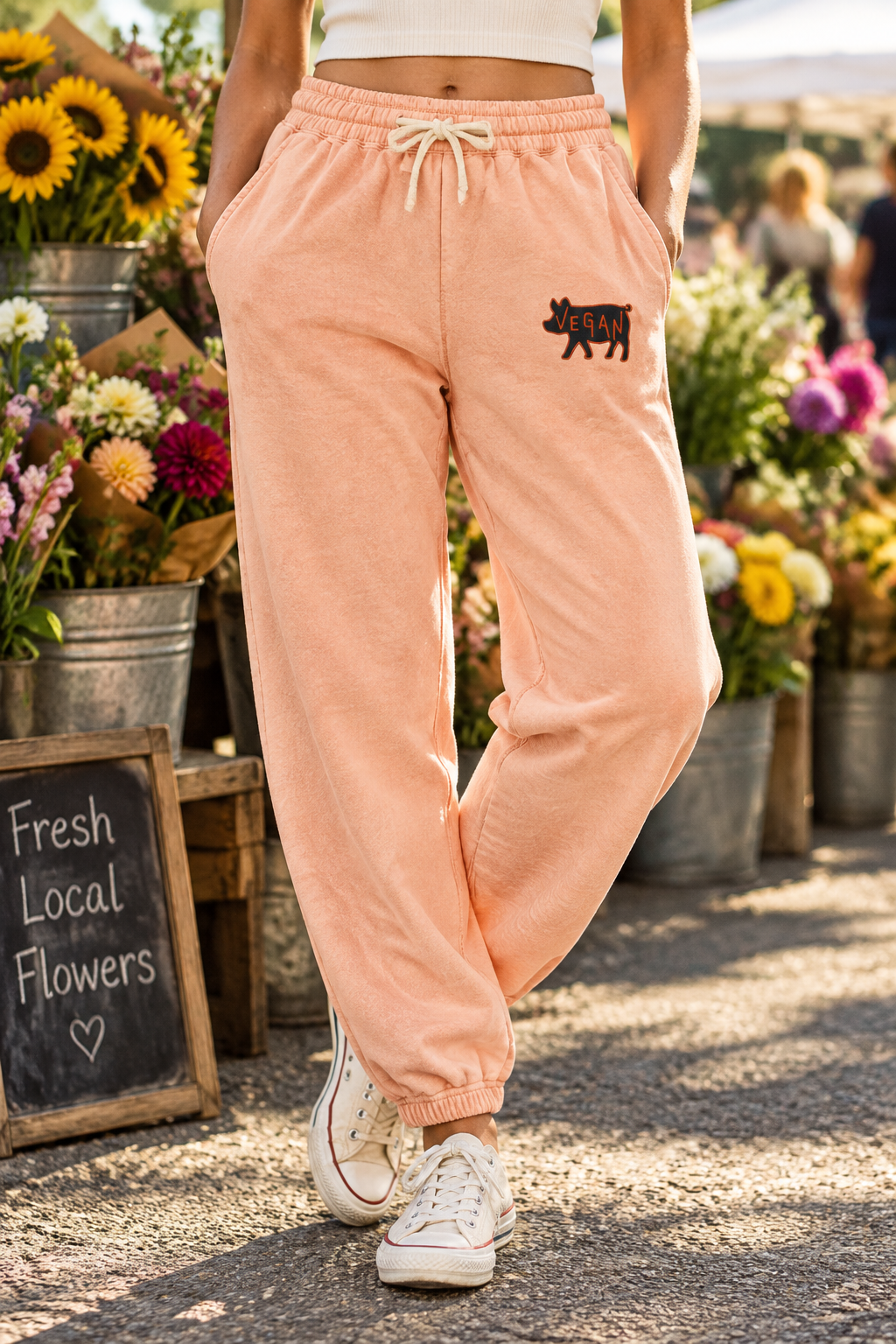 Model at a flower market wearing Peachy vegan embroidered cotton sweatpants