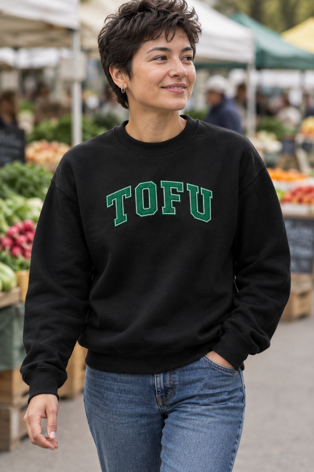 Model wearing black TOFU embroidered crewneck sweatshirt at a farmers market