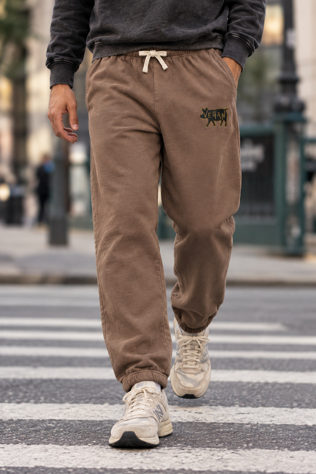 Model walking at a crosswalk wearing Espresso vegan embroidered cotton sweatpants