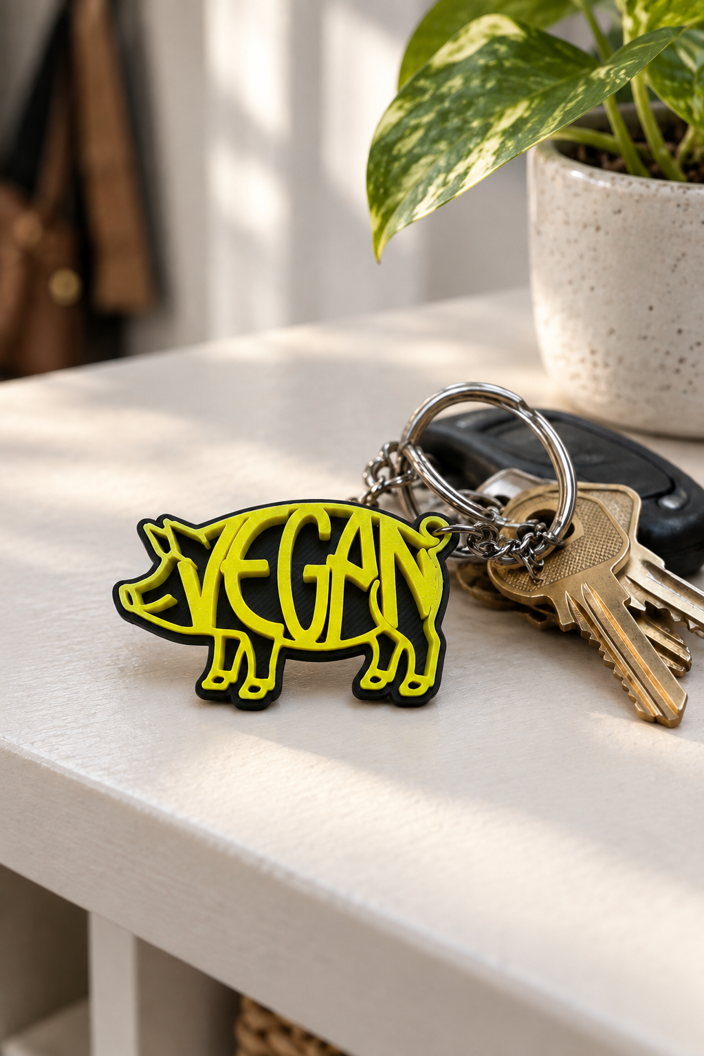 Yellow/black VEGAN pig keychain on entryway shelf